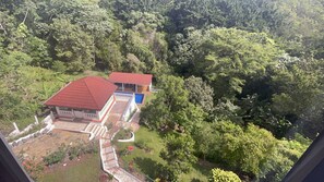 Ein Haus mit rotem Dach, Schwimmbad und Garten.