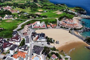 Stunning coastal town with a mix of residential and commercial buildings, set against a backdrop of green fields and a scenic coastline.