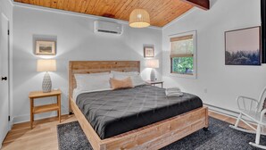 Une chambre à coucher avec un lit en bois, une table de chevet, une lampe et un fauteuil à bascule.