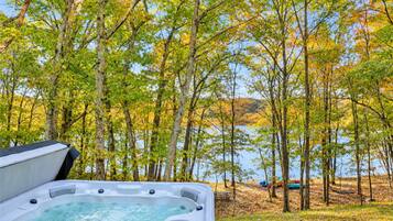 A hot tub with a view of a lake and trees.