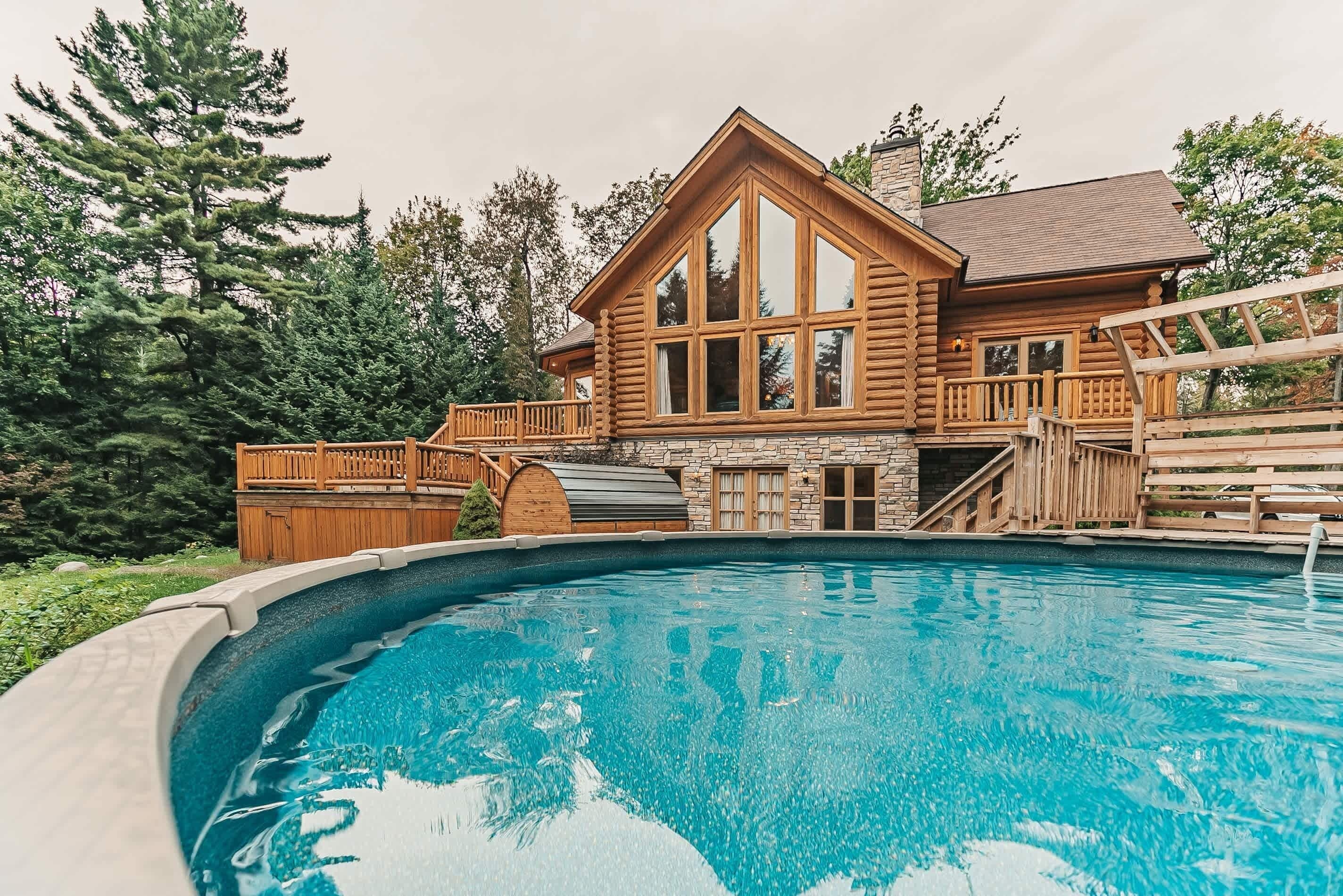 Inviting pool area with wooden deck and cabin backdrop