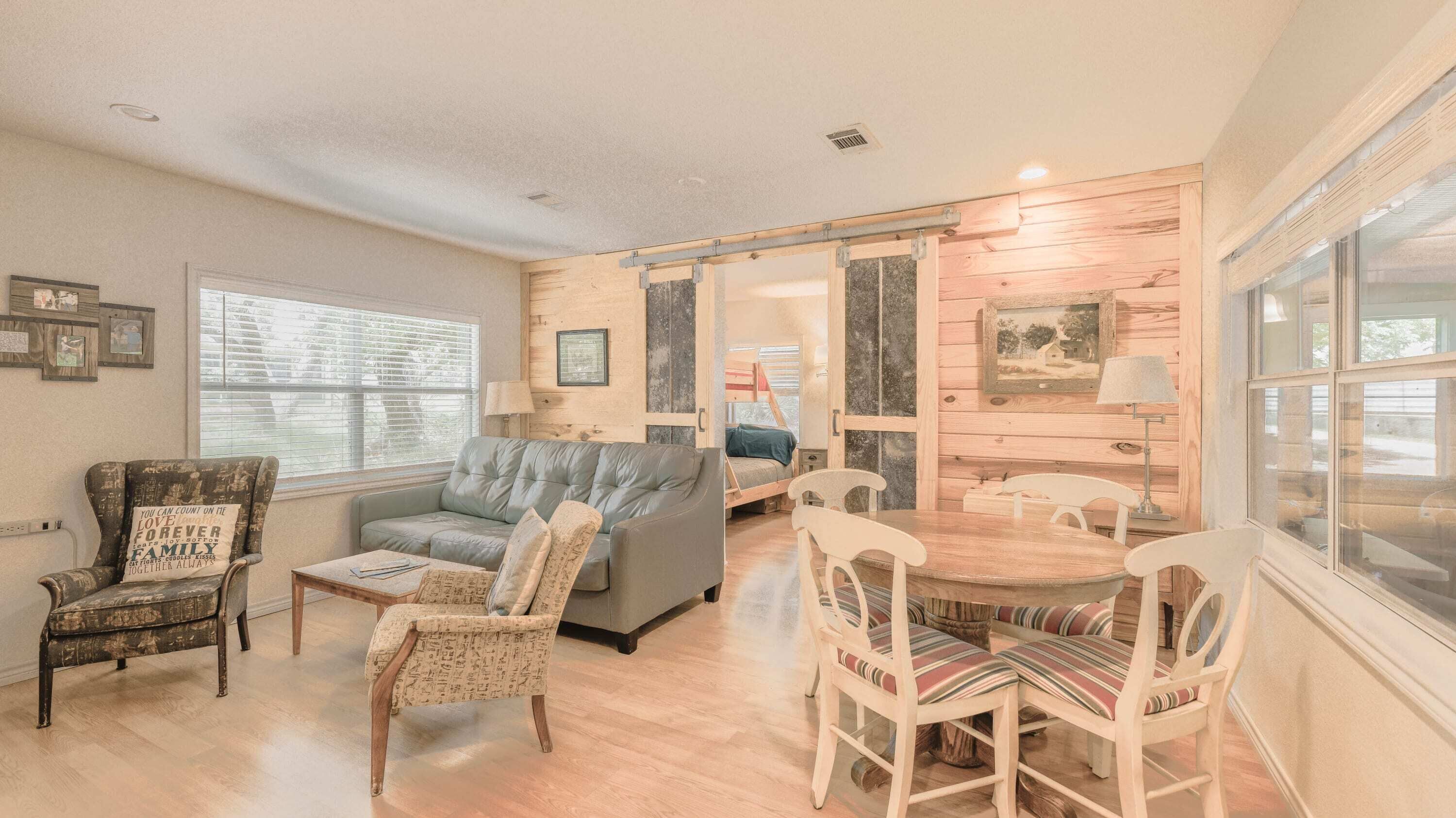 Una sala acogedora con sofá, sillas, mesa de comedor y una litera.