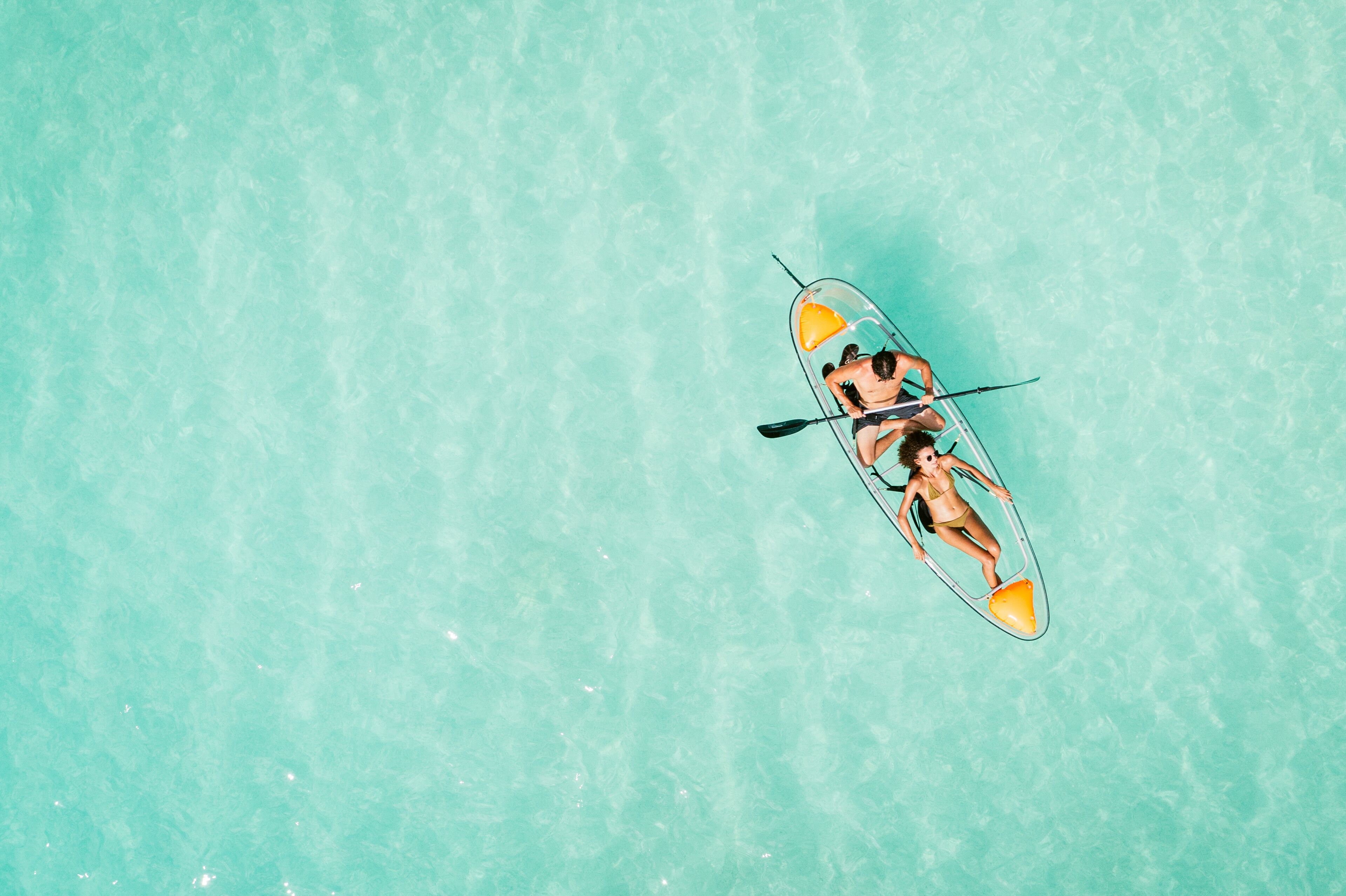 A clear turquoise water body with a person in a kayak.