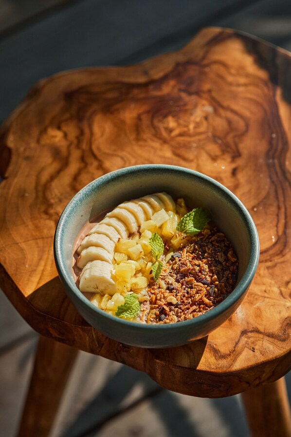 A bowl of food on a wooden table. - Our Habitas Bacalar – Adults Only (Bacalar)