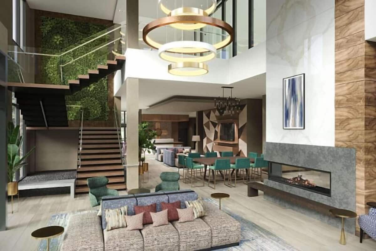 Eine geräumige Lobby mit moderner Treppe, Kamin und einer Sitzecke.