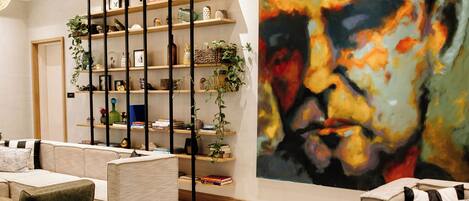 A modern interior with a large abstract painting, a wooden ceiling, and a variety of seating arrangements.