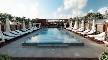 Una piscina al aire libre, sombrillas, tumbonas