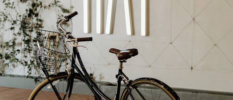 A bicycle with a basket against a wall with a geometric pattern and the text "the RAY".