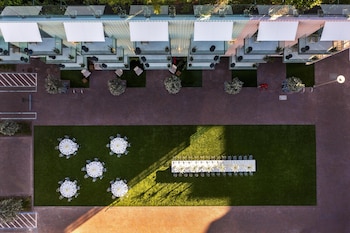 A spacious atrium with large windows, a staircase, and a patterned carpet. at The Ray Hotel Delray Beach, Curio Collection by Hilton