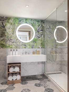 A modern hotel room with two beds, a desk, a TV, and a wardrobe. at The Ray Hotel Delray Beach, Curio Collection by Hilton