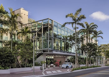 A spacious, modern lounge area with a variety of seating options, including sofas, chairs, and a bar area. at The Ray Hotel Delray Beach, Curio Collection by Hilton