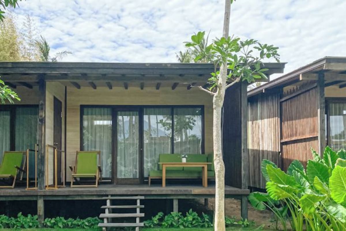A modern outdoor seating area with a wooden deck, a table, and chairs.
