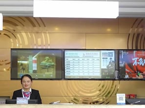 A reception desk with multiple screens displaying information.