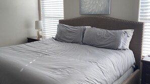 A neatly made bed with a headboard, a bedside lamp, and a wall-mounted artwork. - Come and Enjoy the Beauties of Southern Utah (La Verkin)
