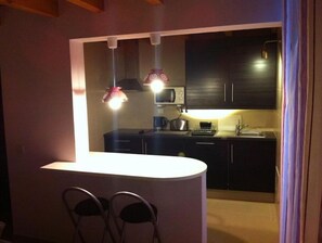 Enjoy cooking in this well-equipped kitchen with a central island, sink, and stove.
