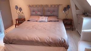Cozy bedroom with a large bed, two bedside tables, and a wardrobe.