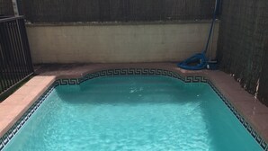 A clear blue pool with a geometric tile border.