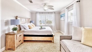 A bedroom with a bed, bedside table, lamp, and a window with curtains. - Summer SPECIAL! Steps 2 Beach! Waterview! Pets Welcome! (Pensacola)