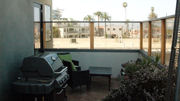 A balcony with a grill, a chair, and a small table. - Spectacular Townhome Close to Beach (Los Angeles)