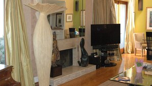 A living room with a fireplace, a television, and a glass coffee table. - Spectacular Townhome Close to Beach (Los Angeles)
