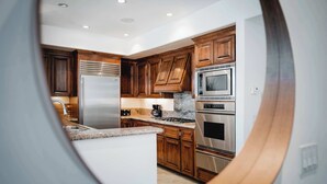 A modern kitchen with wooden cabinets, stainless steel appliances, and a granite countertop. - Your Trendy San Diego Home, 2-Bedroom with Private 2-Car Garage (San Diego)