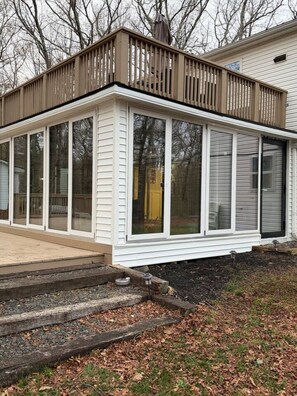 A single-story house with a covered porch, large windows, and a visible yellow door. - Poconos Oasis • 75` Theater • Hot Tub • Pool Table (Cresco)