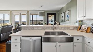 Una cocina moderna con armarios blancos, un lavamanos de acero inoxidable y una isla grande.