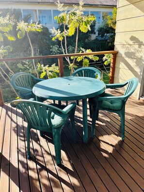 A wooden deck with a round table and four chairs. - Bermagui Bay Beach House - Bungalow. Pet friendly in the heart of town. (Bermagui)
