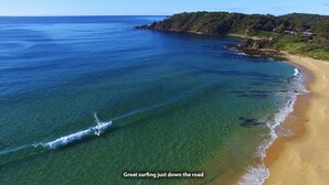A coastal view with clear waters and a sandy beach.