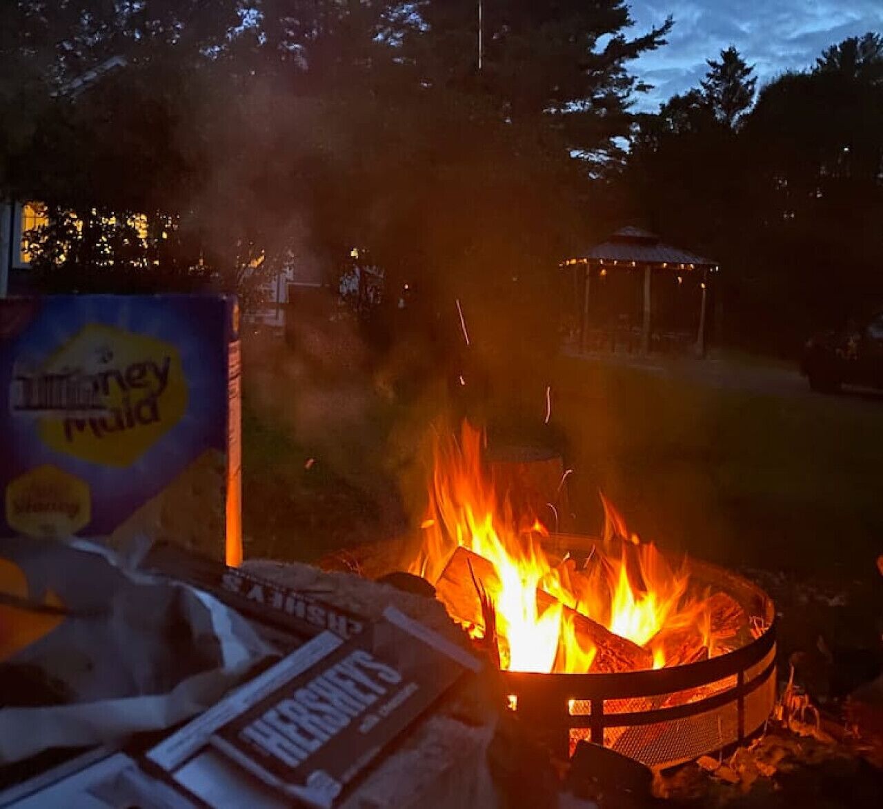 A campfire with a box of Hershey's chocolate and a sign for DUMSTEY MUD.