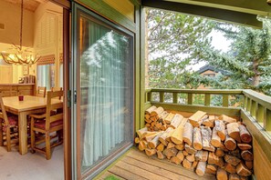 Un patio in legno con una porta vetrata che dà su un'area pranzo con tavolo e sedie.