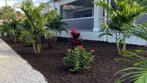 Propiedad residencial con un jardín bien cuidado, con diversas plantas y un camino de grava.