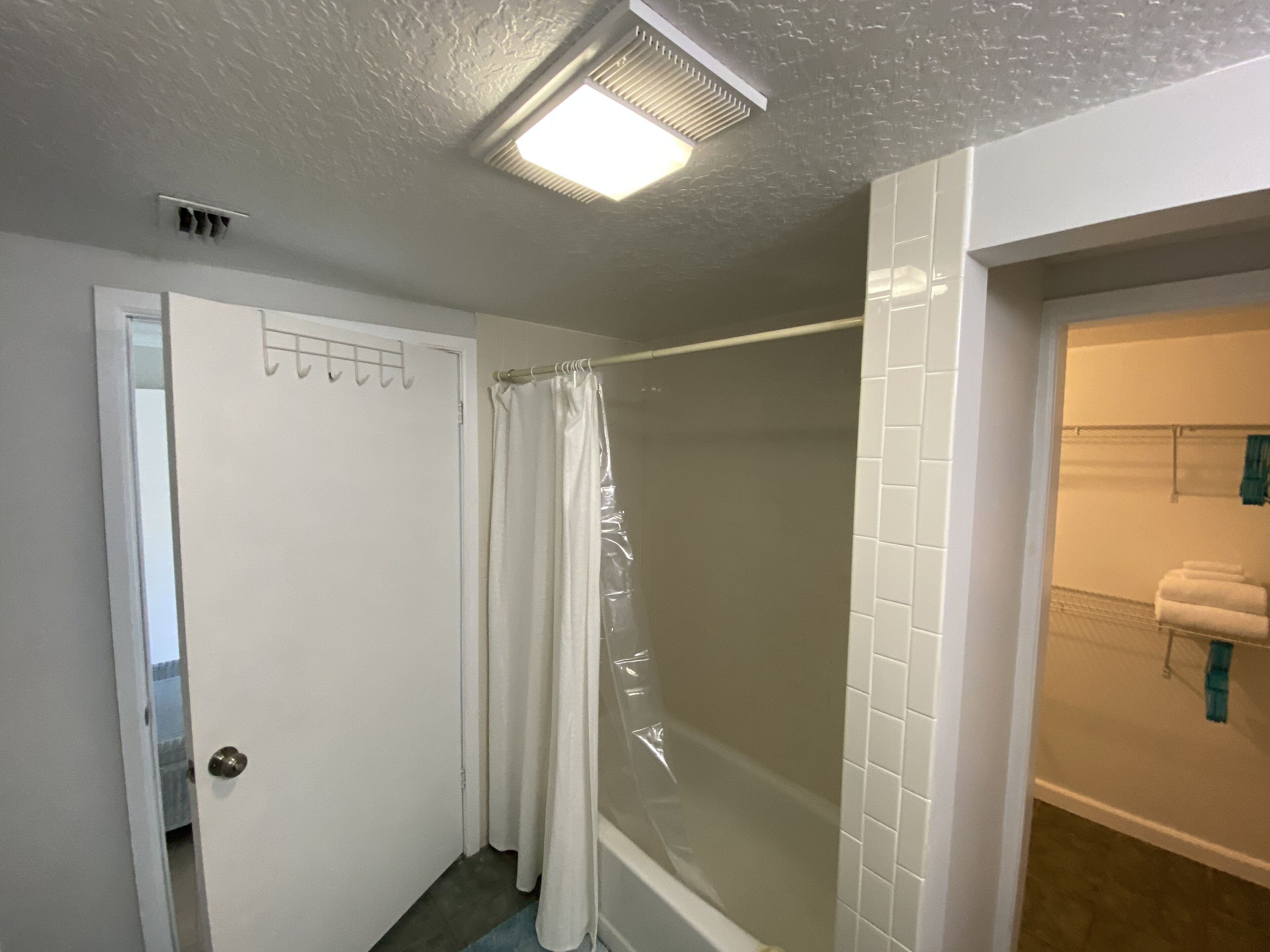 A bathroom with a shower, a toilet, and a sink.