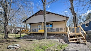 A single-story cabin with a covered porch, a small deck, and a staircase leading to the porch. - Kayaks & Boat Slip: Waterfront Hot Springs Home! (Hot Springs)