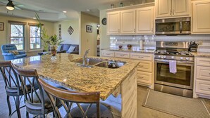 A kitchen with granite countertops, stainless steel appliances, and white cabinetry. - Kayaks & Boat Slip: Waterfront Hot Springs Home! (Hot Springs)
