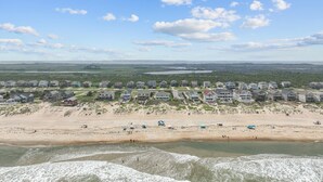 A coastal residential area with beachfront properties and a beach in the foreground.