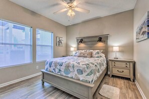 A bedroom with a bed, nightstands, a ceiling fan, and a window with blinds. - Walk to Destin Beach: Coastal Condo w/ Pool Access (Destin)
