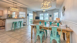 A spacious kitchen with a wooden island, teal chairs, and pendant lights. - Walk to Destin Beach: Coastal Condo w/ Pool Access (Destin)