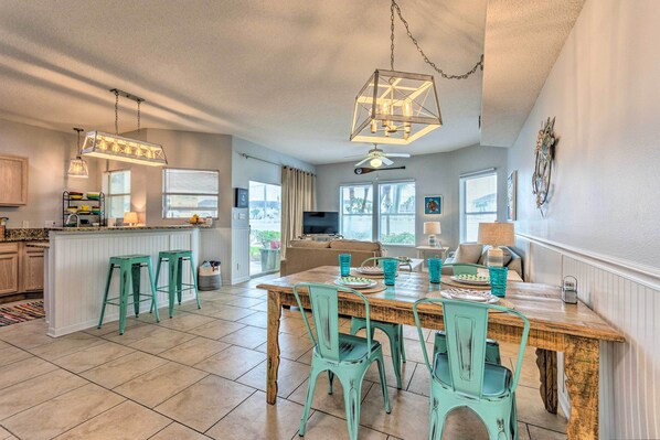 A spacious kitchen with a wooden island, teal chairs, and pendant lights. - Walk to Destin Beach: Coastal Condo w/ Pool Access (Destin)