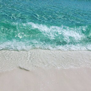 A beach with clear turquoise water and white sand.