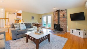 A spacious living room with a fireplace, a television, and a dining area.