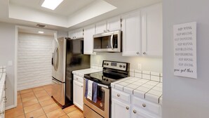 A modern kitchen with white cabinets, stainless steel appliances, and a tiled backsplash. - Tucson Townhome w/ Private Patio & Mtn Views! (Tucson)