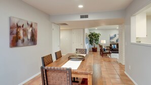 A spacious dining area with a long wooden table, several chairs, and a large painting on the wall. - Tucson Townhome w/ Private Patio & Mtn Views! (Tucson)