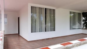 A room with large windows, a wooden floor, and a white wall. - Casa Vacacional San Andres (San Andrés)