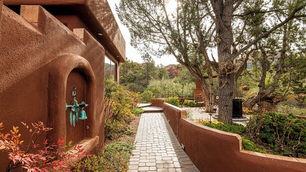 A pathway leading to a building with a unique architectural design, surrounded by trees and shrubs. - Discover luxury at Sedona Hidden Dream, a spacious 4BR retreat with stunning red rock views. (Sedona)