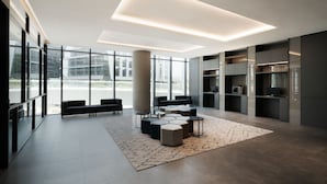 Un intérieur moderne avec un espace salon, de grandes fenêtres et des rangements intégrés.