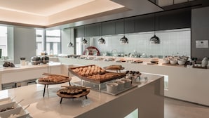 Une cuisine moderne dotée d’un îlot central où sont présentés divers produits de boulangerie et pâtisserie.