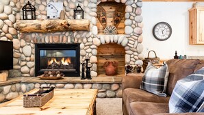 Una sala acogedora con chimenea de piedra, televisor y sofá cómodo.