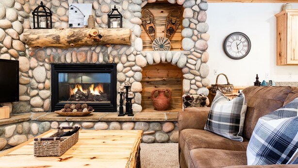 Una sala acogedora con chimenea de piedra, televisor y sofá cómodo.