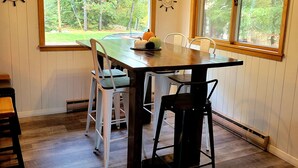 A dining area with a wooden table, white chairs, and a ceiling fan. - Northern Paradise on Lake Vermilion - Year Round Home (Tower)